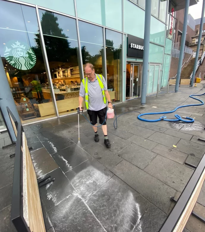 Paul Dyson pressure washing Starbucks patio area.