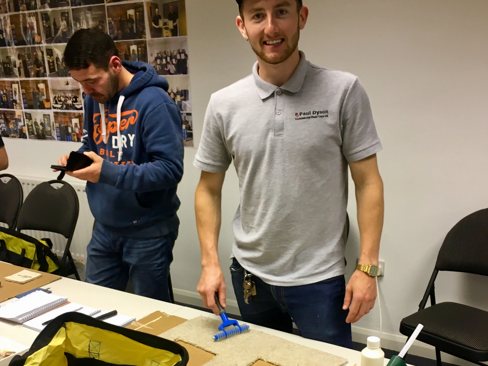 Harry from Paul Dyson at a carpet repair workshop, with tools like a glue gun and a carpet brush visible.