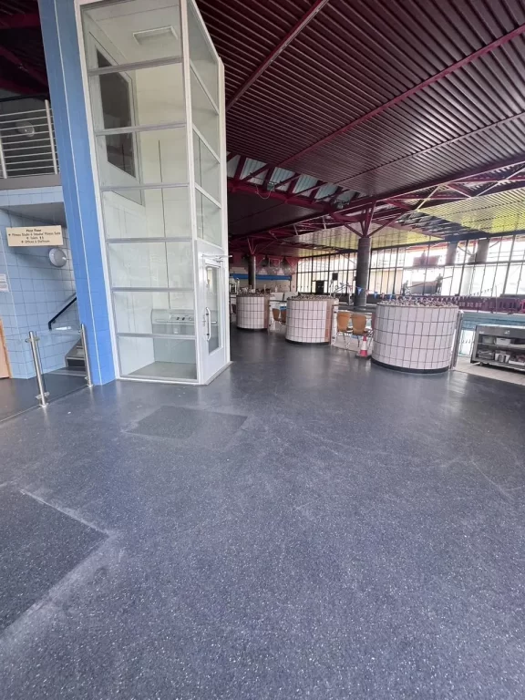 A large hall of a swimming pool centre before carrying out floor restoration services.