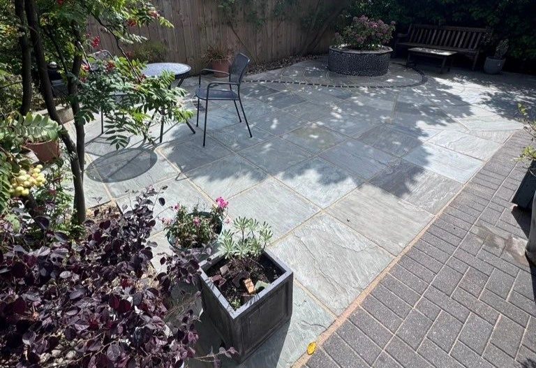 
Gemini said
Clean, dry stone patio featuring grey flagstones, potted plants, and outdoor furniture in a sunny garden.