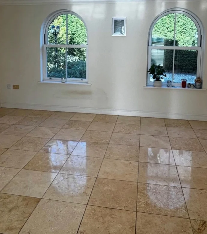 Recently restored natural stone flooring in large residential home with arched windows.