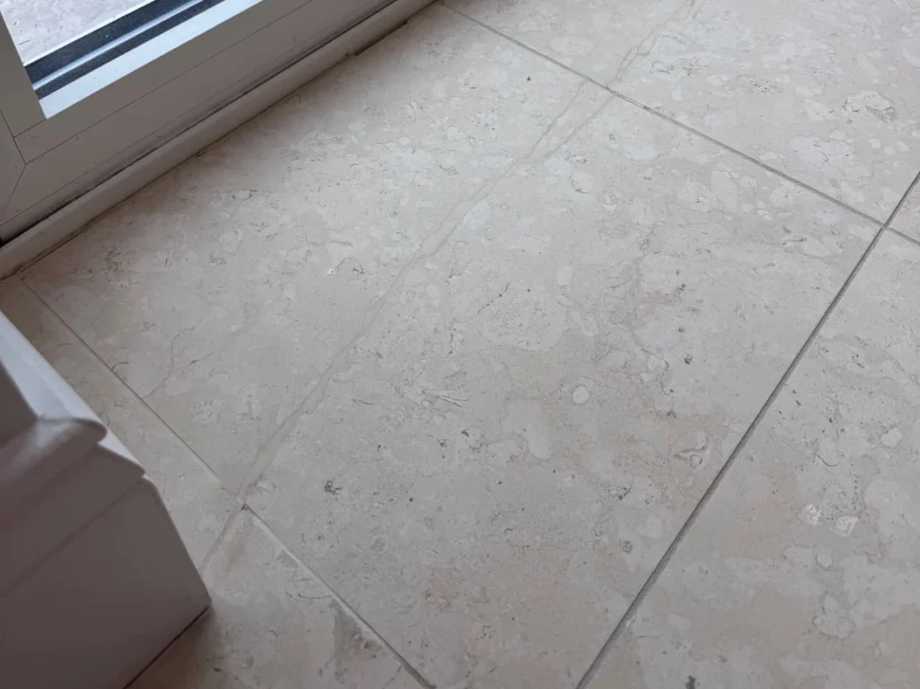 A limestone floor with a crack that has been filled in.