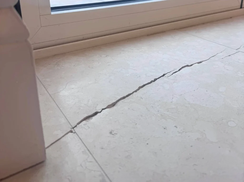A crack in limestone flooring.