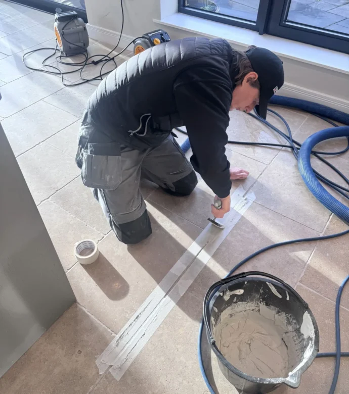 A member of the Paul Dyson team re-grouting a natural stone floor.