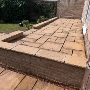 Freshly cleaned patio with sand coloured stone on sunny day.