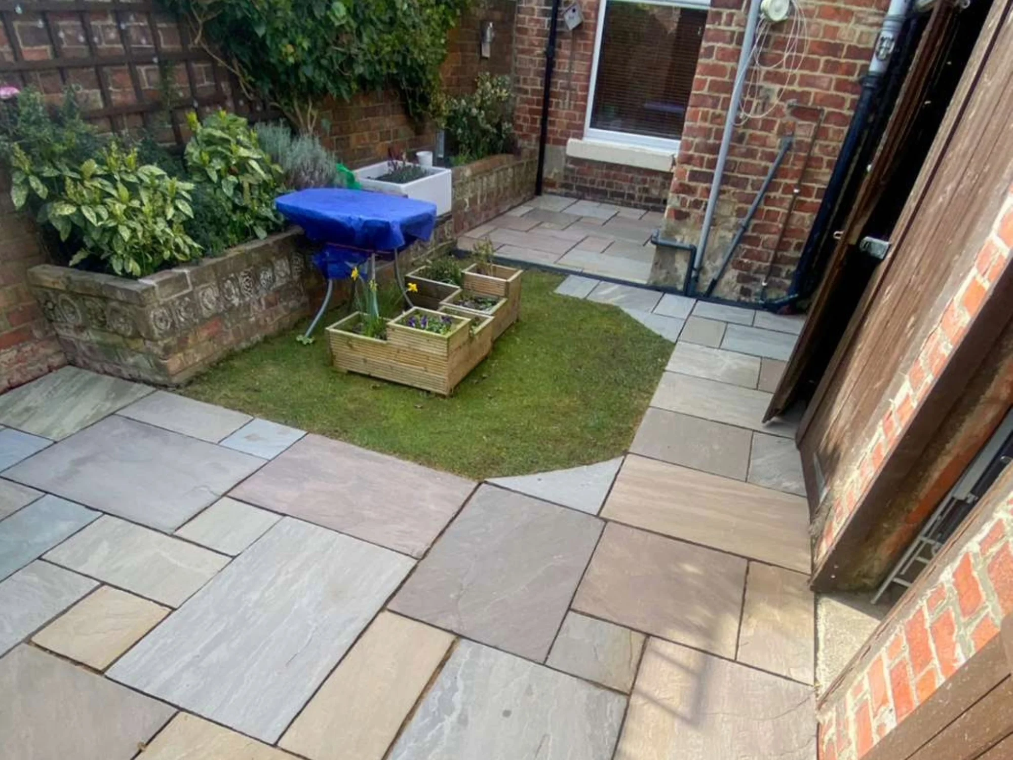 Freshly cleaned patio in back yard of terraced house.