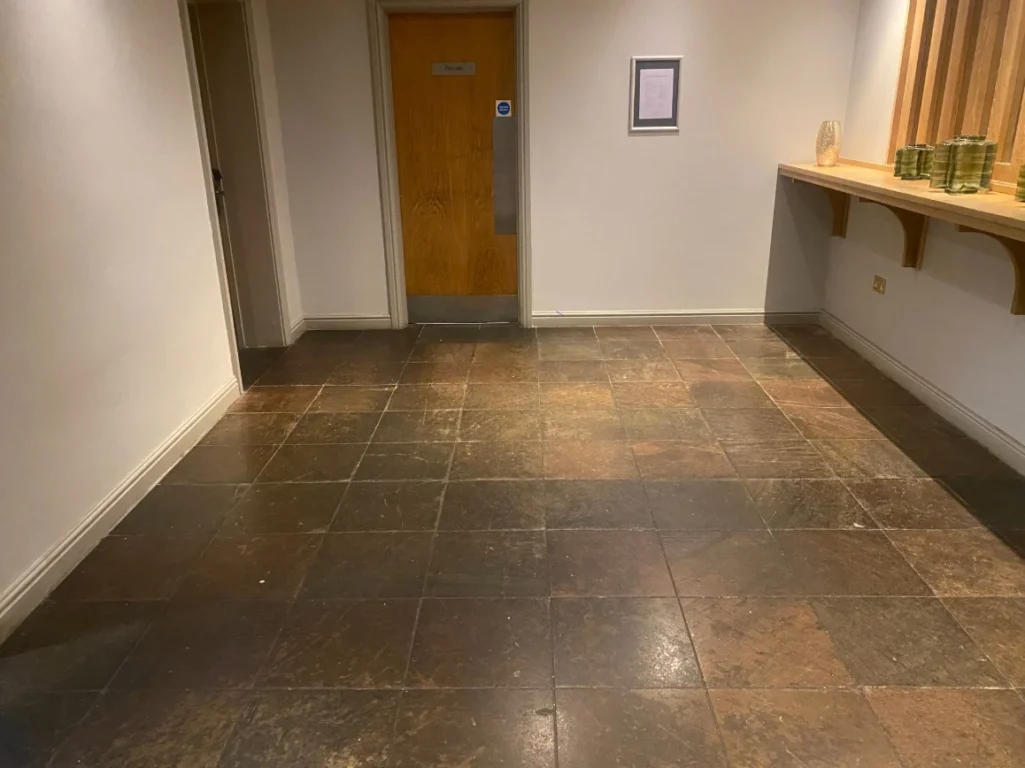 A dull natural stone floor in need of re-sealing.