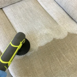 A cream linen sofa that's half wet, half dry, being professionally cleaned.